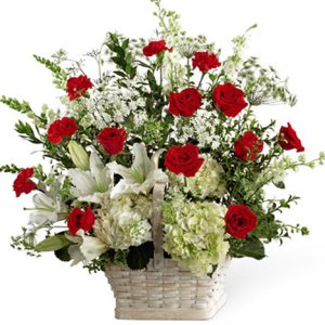 A bountiful basket of striking red and white blooms to express your sympathy and honor the departed
