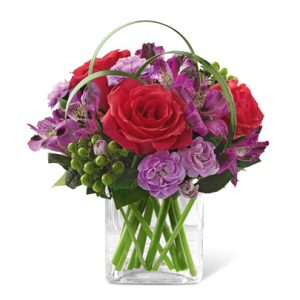 Send a gift that's sure to get noticed with this striking red and lavender bouquet nestled in a petite glass cube. Featuring roses