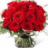 this distictive design features gorgeous red roses in a compact bouquet accented with lily grass and other fresh greens and nestled in a contemporary glass cylinder that is lined with aspidistra leaves or similar for a unique custom-designed look. Stylish