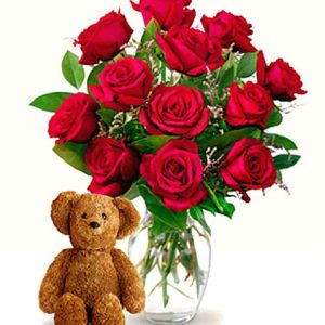 Send someone special a great big hug with this sure-fire combination of one dozen beautiful red roses vased with a loveable teddy bear