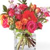 contemporary bouquet of fresh seasonal blooms displayed in a clear glass cinch or cylinder vase. This uplifting arrangement includes roses