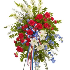 A graceful standing sympathy spray of stately lilies