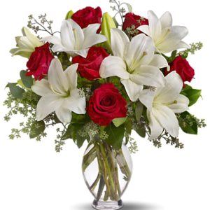 Express your love with this stunning combination of velvety red roses and garden-fresh lilies designed with fresh foliage in a classic glass vase. A beautiful choice for love