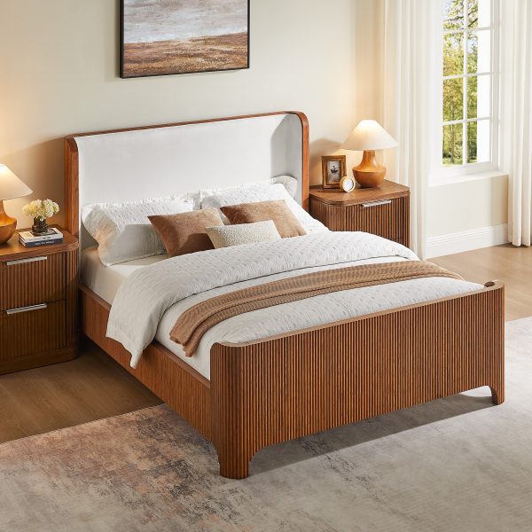 a beautifully handcrafted piece made from solid oak with refined vertical slat detailing that brings texture and architectural elegance. The softly curved headboard is upholstered in plush
