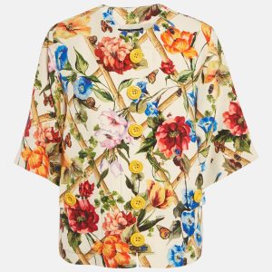Dolce and Gabbana brings elegance to outerwear with this cream crepe jacket adorned with floral prints. The button front design adds polish