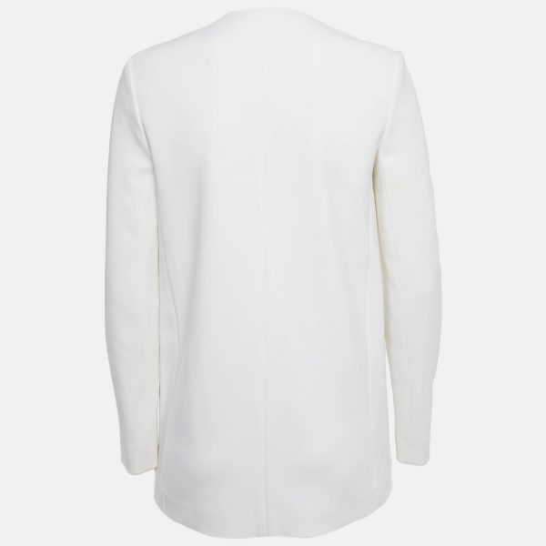 its sharp tailoring softened by the fluid fall of the fabric. The double breasted front with contrasting buttons brings a touch of edge