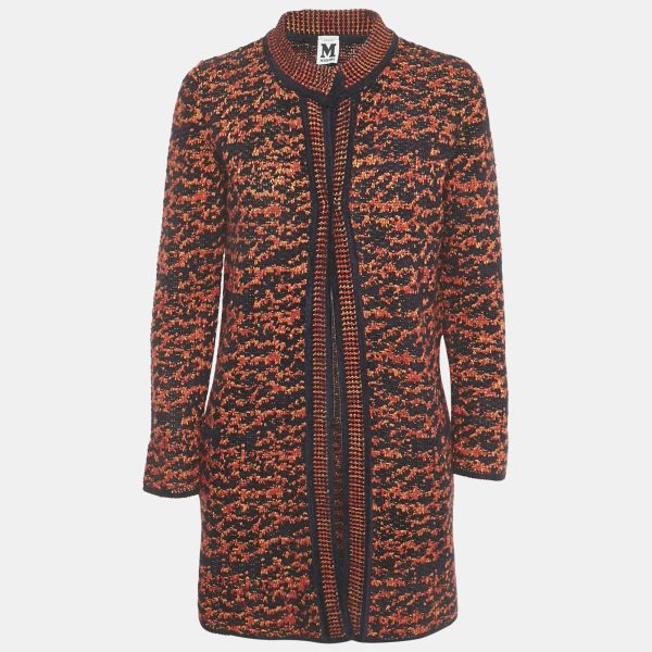 M Missoni’s coat pairs navy and red yarns in a textured knit. The longline cut and understated finish let the colourwork take focus. Signature patterning for effortless outerwear.