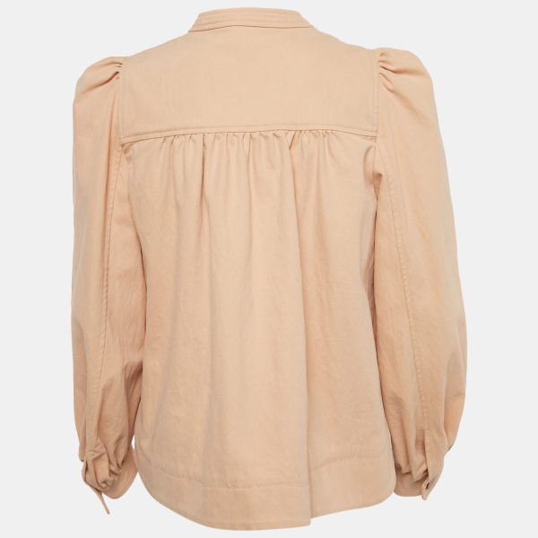 its puffed sleeves adding volume to a familiar form. The neutral shade pairs easily with denim or light dresses